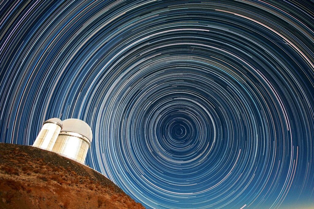 Kruhové světelné stopy hvězd nad kopulí astronomického dalekohledu.